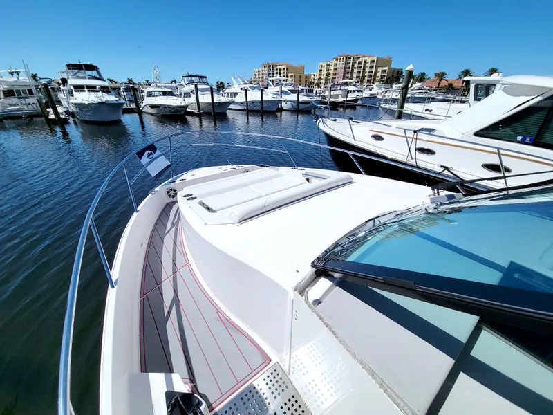 Slide: The Image of 2021 Regal 36 XO yacht docked in a marina, surrounded by other boats under a clear blue sky. - 39