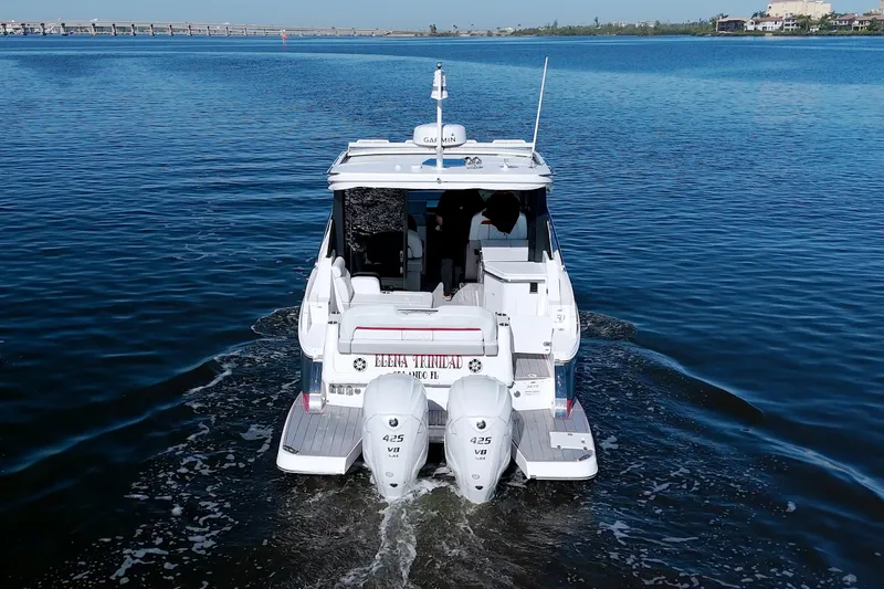 Slide: The Image of 2021 Regal 36 XO boat cruising on calm water, rear view. - 6