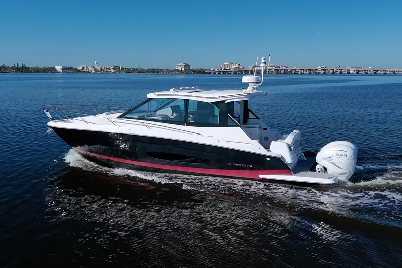 Slide: The Image of 2021 Regal 36 XO boat cruising on a calm blue waterway. - 7