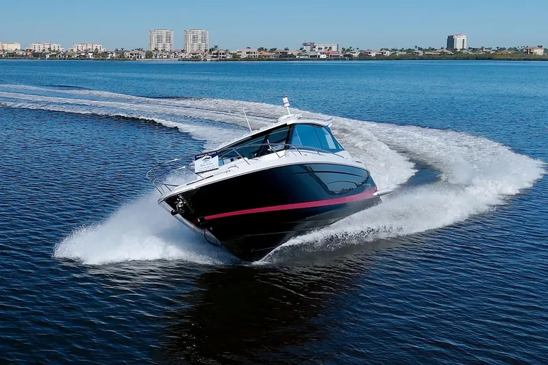 Slide: The Image of 2021 Regal 36 XO boat cruising swiftly on open water. - 9