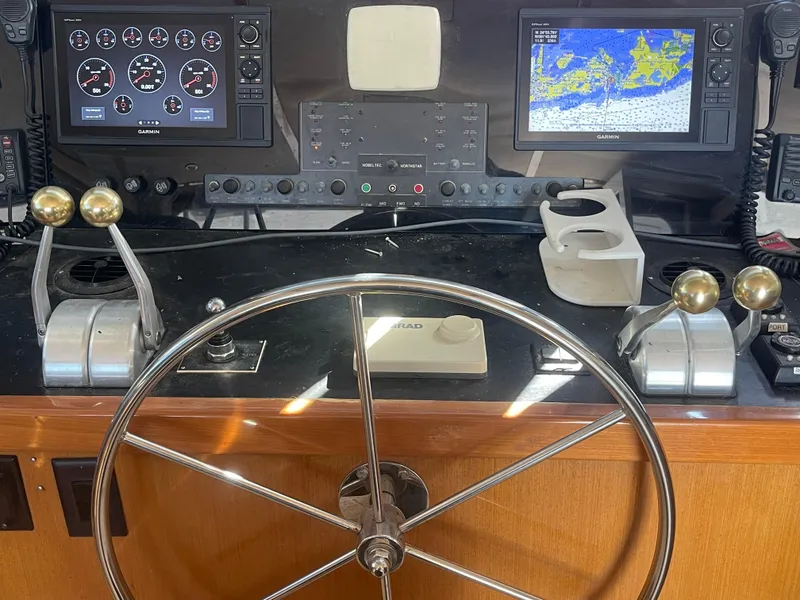 Slide: The Image of Boat helm of a 1999 Viking 58 EB with navigation screens and controls. - 10