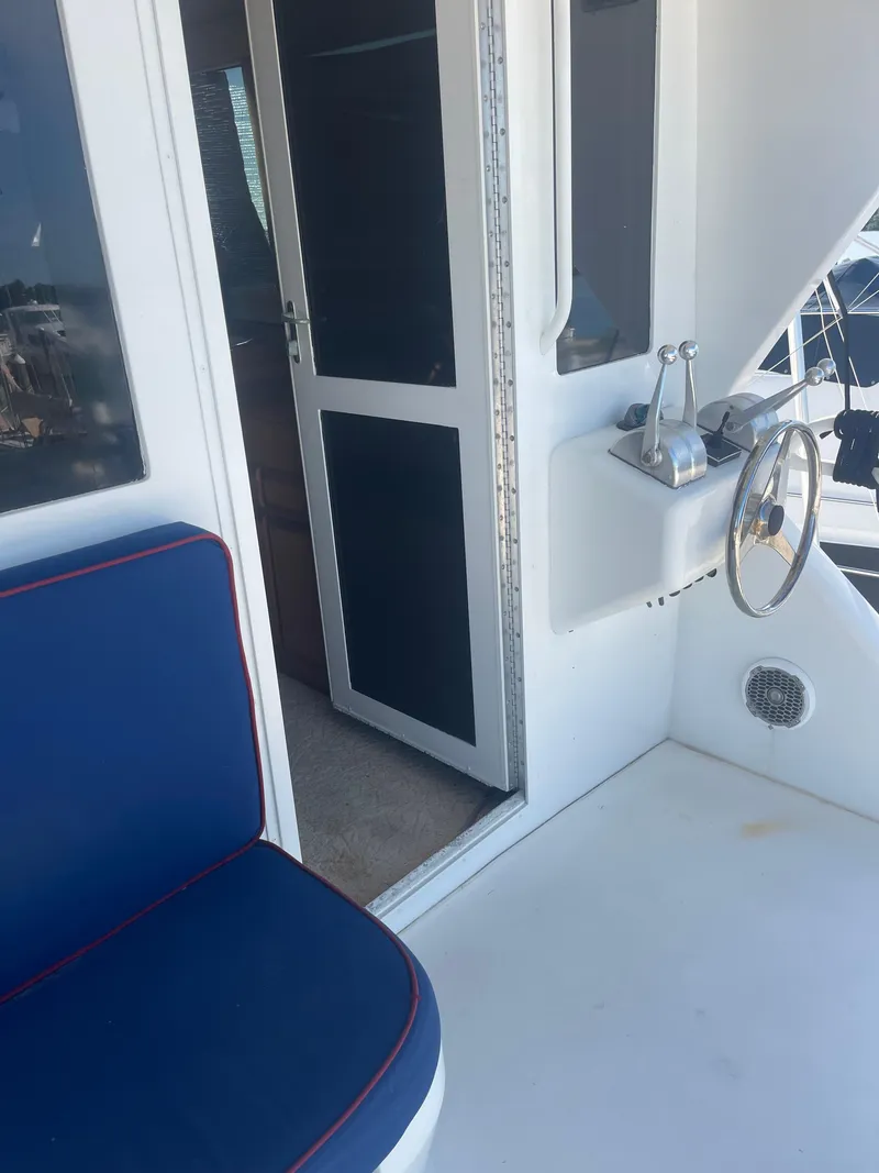 Slide: The Image of 1999 Viking 58 EB yacht interior with blue seating and helm station. - 12