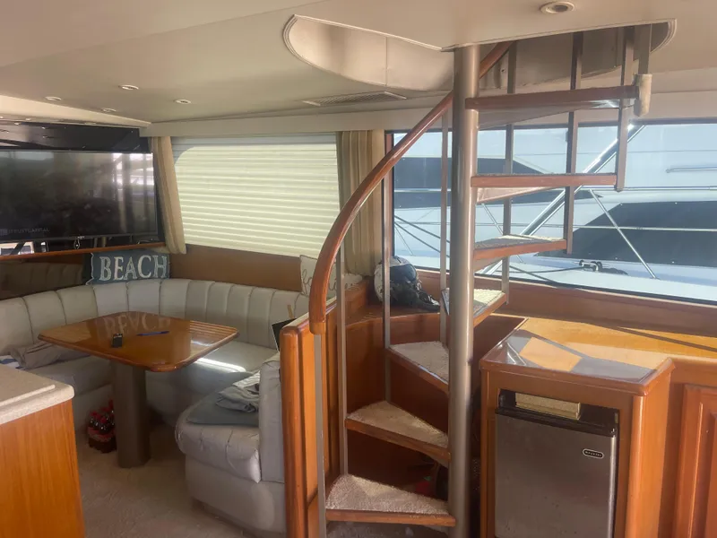 Slide: The Image of Luxurious 1999 Viking 58 EB yacht interior with spiral staircase and cozy seating area. - 15