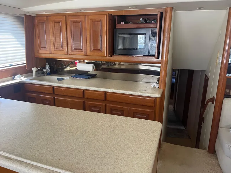 Slide: The Image of 1999 Viking 58 EB yacht kitchen with wooden cabinets and microwave. - 16