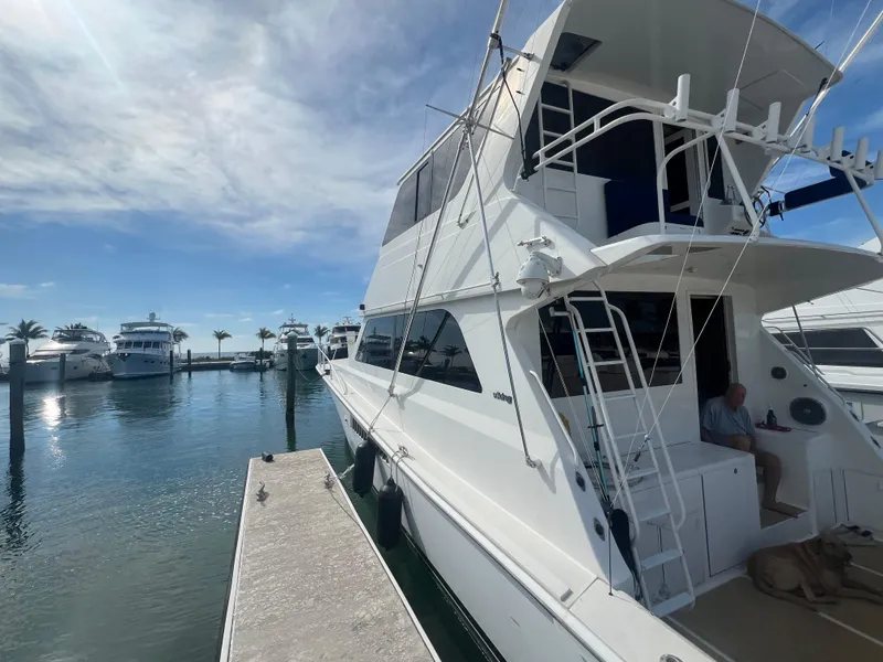 Slide: The Image of 1999 Viking 58 EB yacht docked at marina under clear blue sky. - 2
