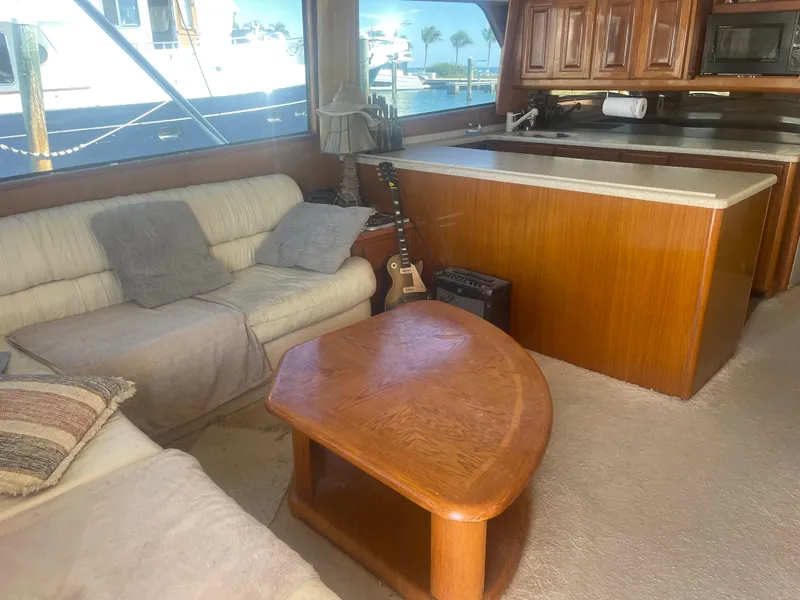 Slide: The Image of Cozy interior of 1999 Viking 58 EB yacht with sofas, guitar, and wooden table. - 21