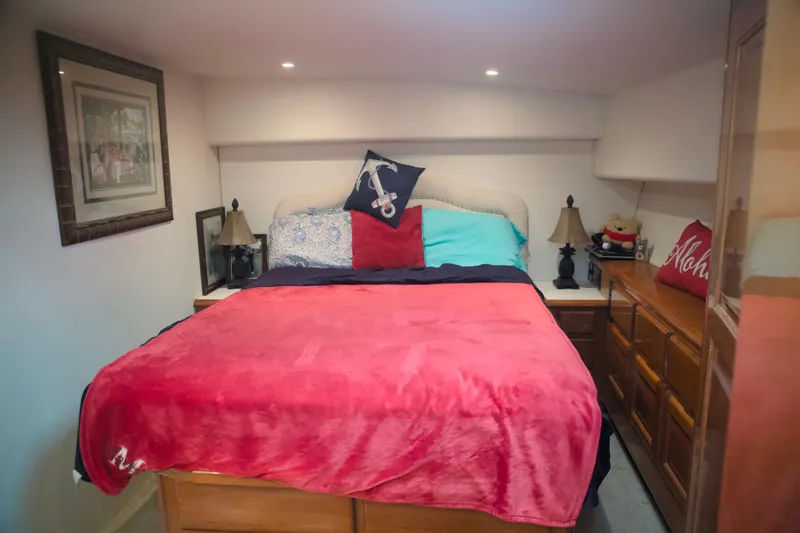 Slide: The Image of Cozy bedroom interior on a 1999 Viking 58 yacht with vibrant bedding and nautical decor. - 25