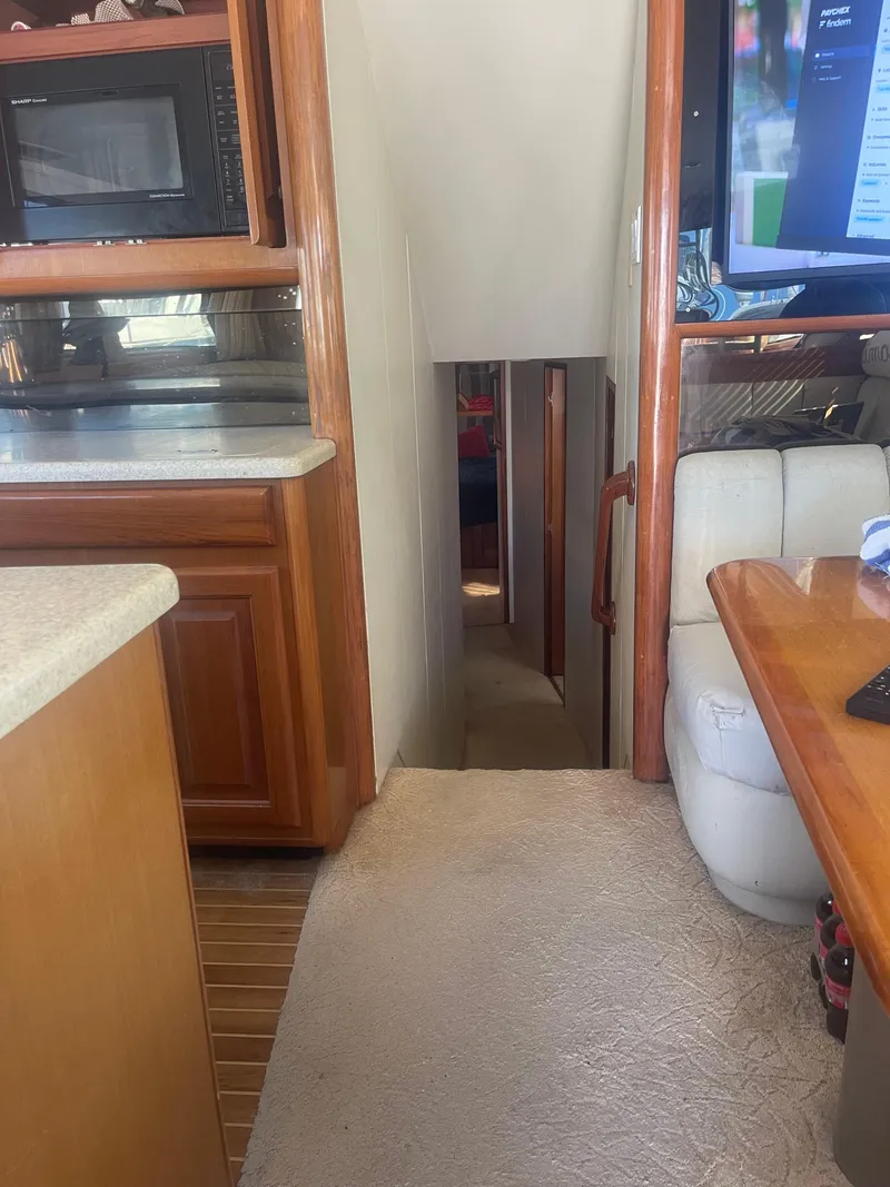 Slide: The Image of Interior of a 1999 Viking 58 EB yacht, featuring a cozy hallway and wooden cabinetry. - 27