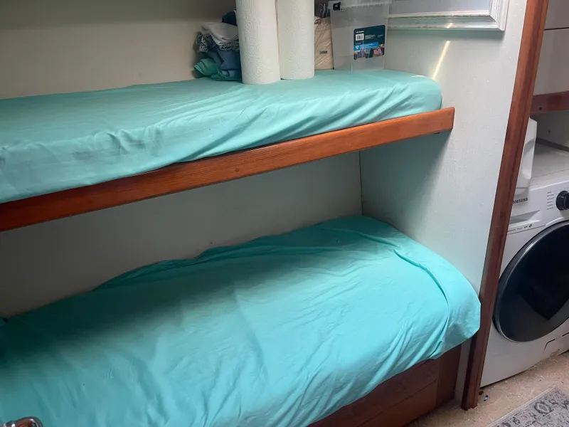 Slide: The Image of Bunk beds with teal sheets in a 1999 Viking 58 EB yacht interior. - 28