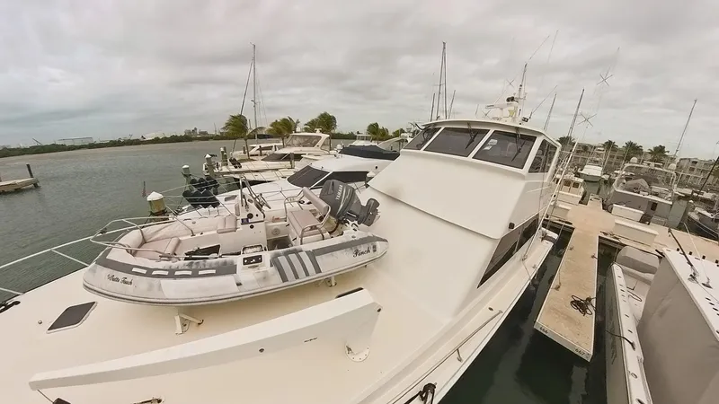 Slide: The Image of 1999 Viking 58 yacht docked with inflatable boat on deck, overcast sky. - 3
