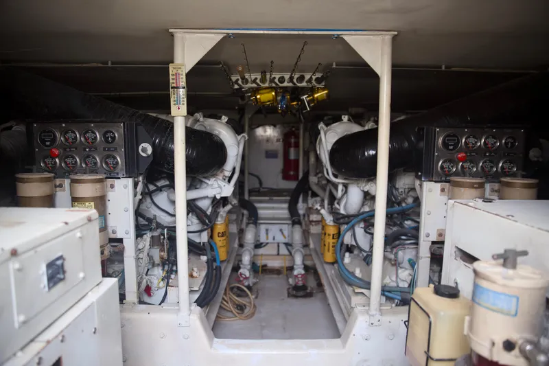 Slide: The Image of Engine room of a 1999 Viking 58 yacht, showcasing dual engines and control panels. - 31