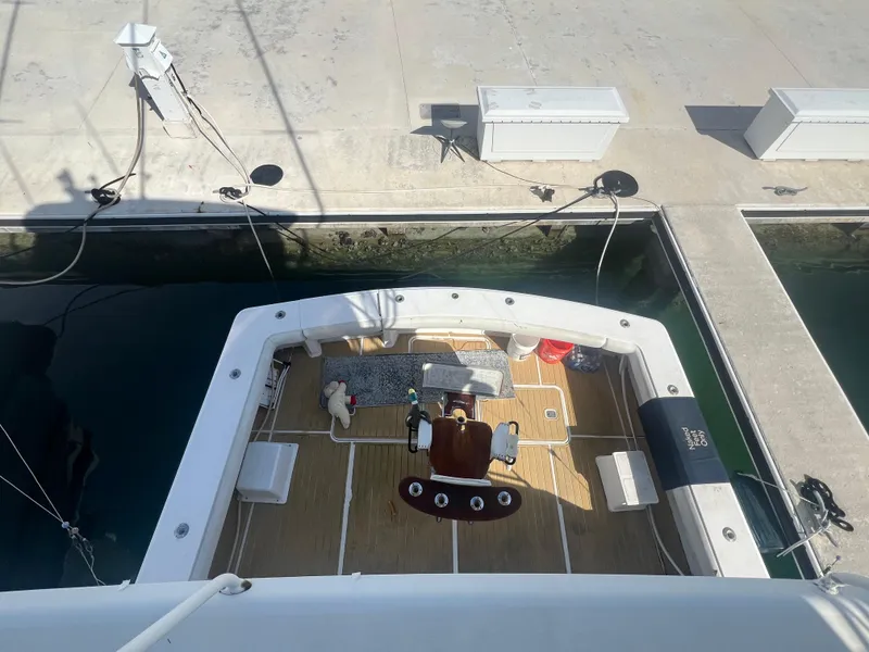 Slide: The Image of 1999 Viking 58 EB yacht docked, aerial view of deck and seating area. - 7