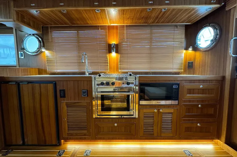 Slide: The Image of Luxurious 2025 Helmsman Trawlers 38 Sedan kitchen with wood finish and modern appliances. - 15