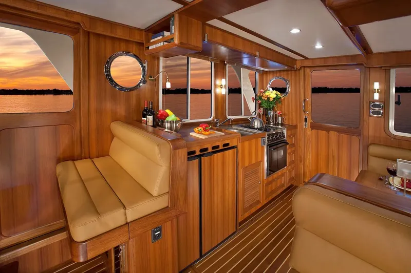 Slide: The Image of Luxurious 2025 Helmsman Trawlers 38 Sedan interior with elegant wood finish and sunset view. - 19