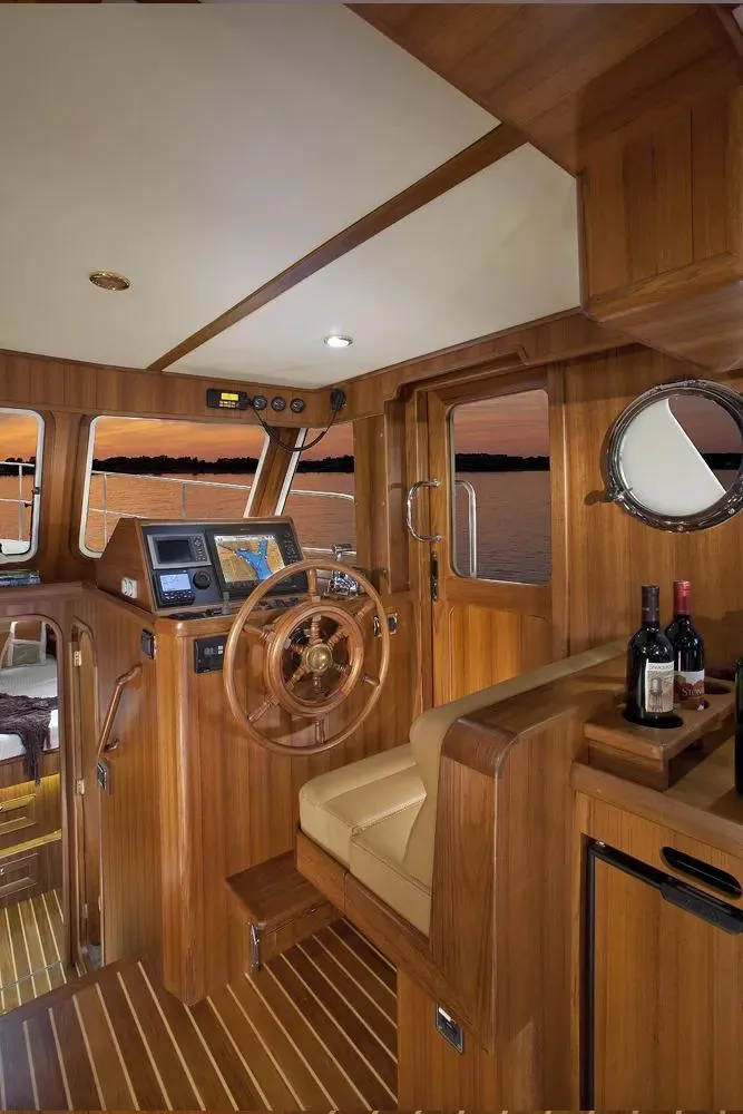 Slide: The Image of Helmsman Trawlers 38 Sedan 2025 interior with wooden finish and navigation equipment. - 20
