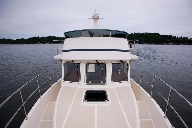 Slide: The Image of 2025 Helmsman Trawlers 38 Sedan on calm water, showcasing sleek design and spacious deck. - 31