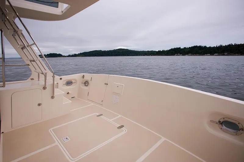 Slide: The Image of Helmsman Trawlers 38 Sedan 2025 boat deck with scenic water view. - 6