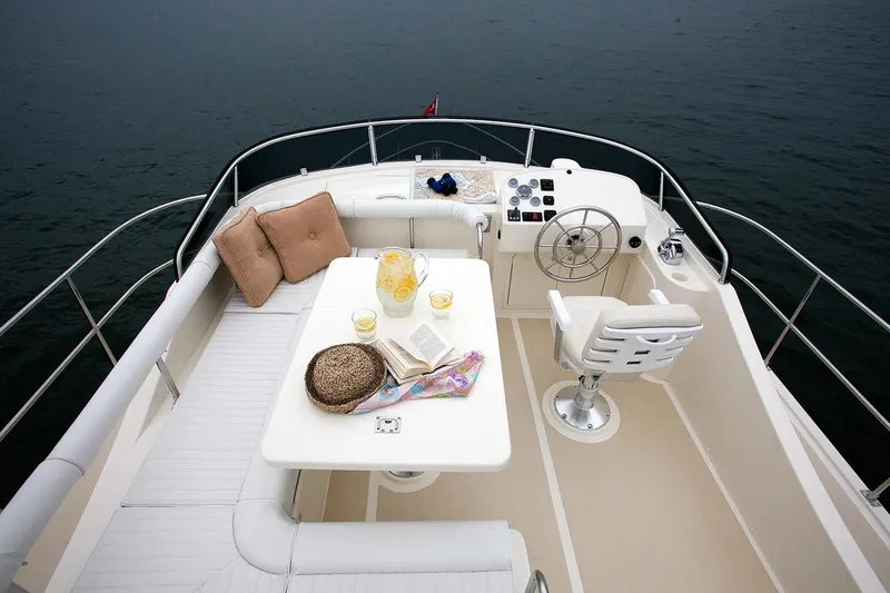 Slide: The Image of Helmsman Trawlers 38 Sedan 2025 yacht deck with seating, table, and helm station. - 9