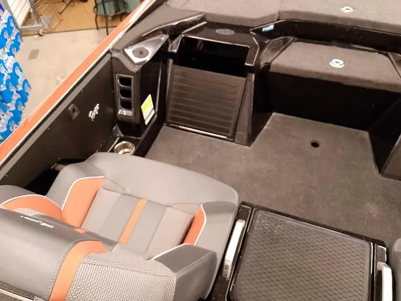 Slide: The Image of 2025 Ranger Z520 SC boat interior with gray and orange seating, storage compartments, and cup holder. - 25