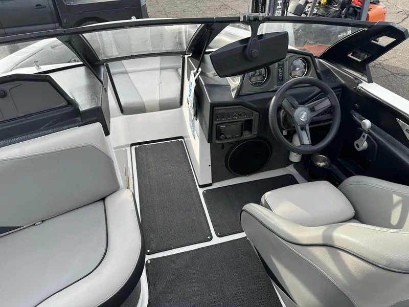 Slide: The Image of 2016 Axis Boats T22 interior with steering wheel, seating, and dashboard controls. - 11