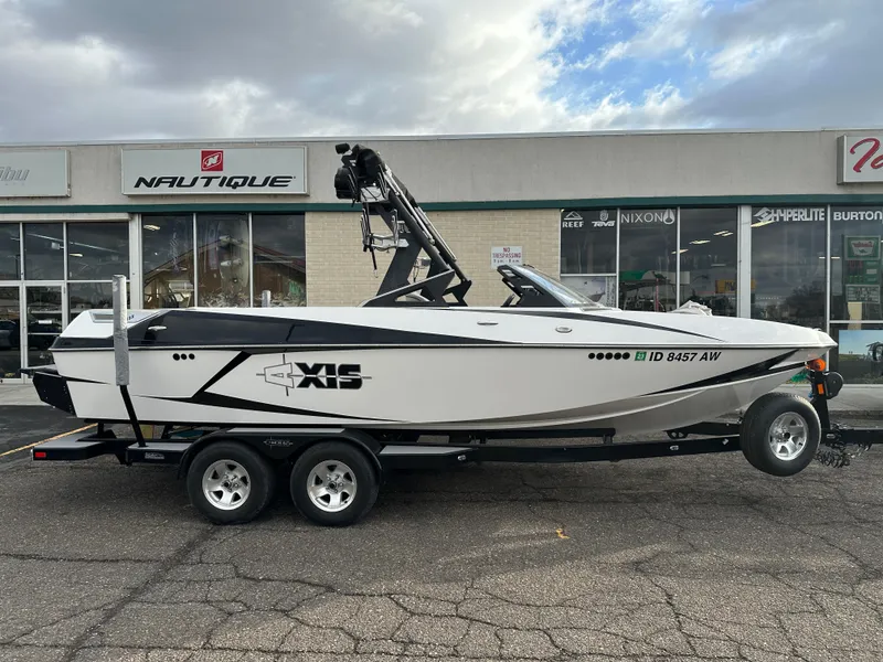 Slide: The Image of 2016 Axis Boats T22 on trailer outside a dealership under cloudy sky. - 3