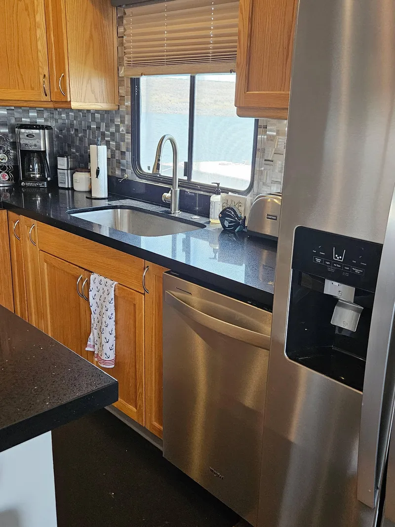 Slide: The Image of Modern kitchen in a 1997 Sumerset houseboat with stainless steel appliances and wooden cabinets. - 13