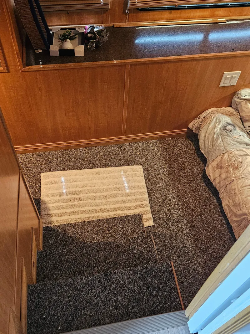 Slide: The Image of Interior of a 1997 Sumerset Houseboat with carpeted stairs and wooden paneling. - 15