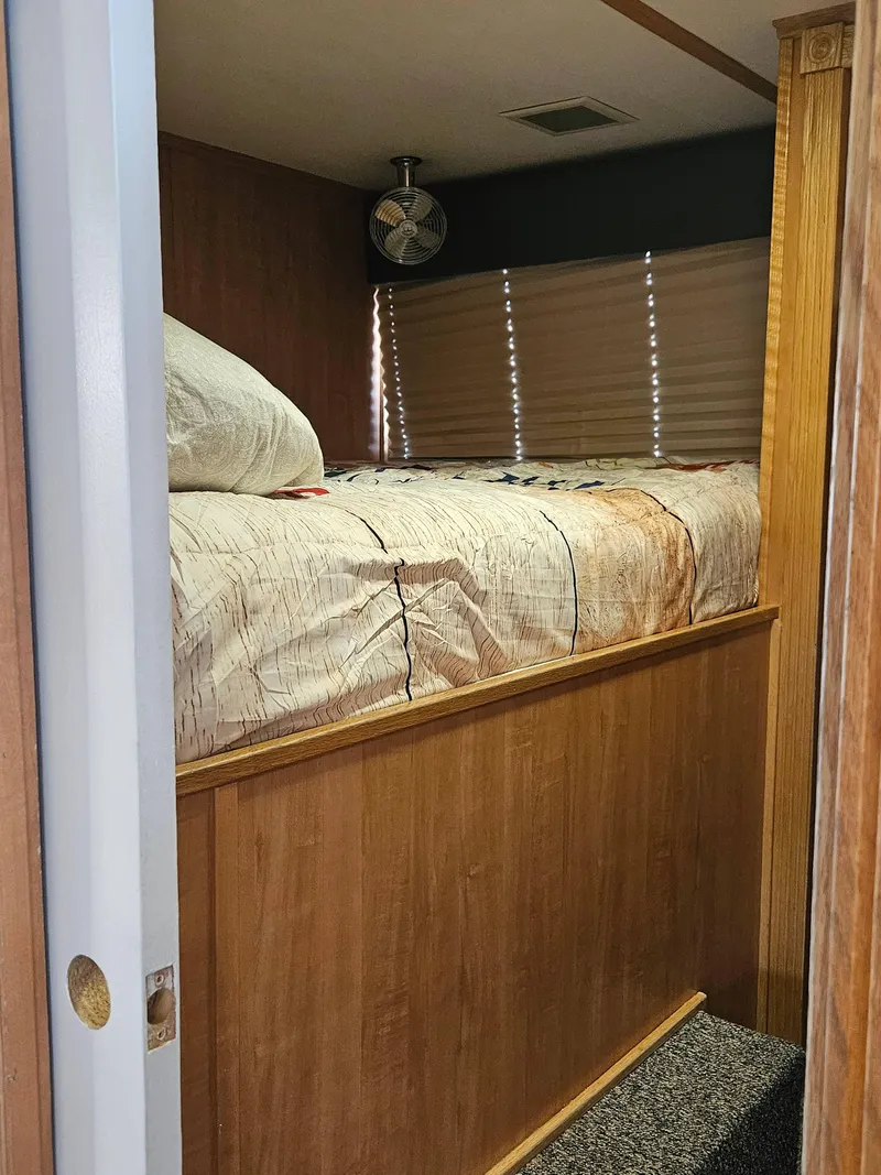 Slide: The Image of Cozy bedroom interior of a 1997 Sumerset Houseboat with wood paneling and a comfortable bed. - 3