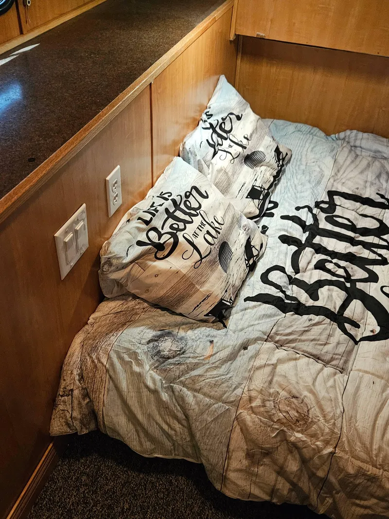 Slide: The Image of Cozy bedroom in a 1997 Sumerset Houseboat with decorative pillows and wooden interior. - 5