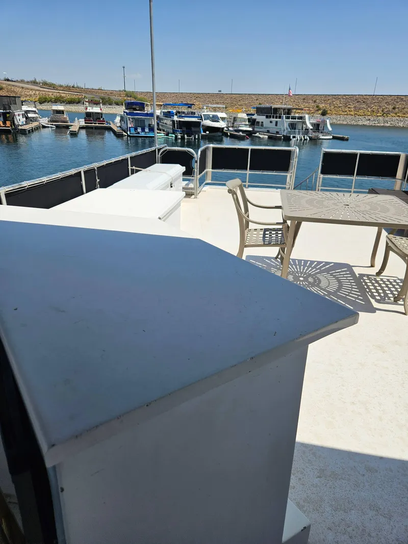 Slide: The Image of 1997 SUMERSET HOUSEBOATS houseboat deck with table, chairs, and marina view. - 6