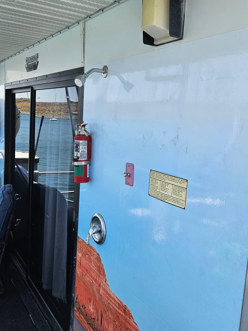 Slide: The Image of 1997 Sumerset Houseboat exterior with fire extinguisher and scenic water view. - 9