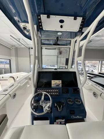 Slide: The Image of 2024 Tidewater 272 CC Adventure boat dashboard with steering wheel and controls. - 12
