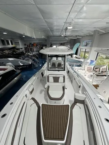 Slide: The Image of 2024 Tidewater 272 CC Adventure boat interior in showroom, featuring sleek seating and modern design. - 16