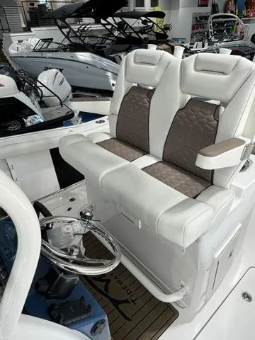 Slide: The Image of 2024 Tidewater 272 CC Adventure boat interior with plush seating and modern steering console. - 18