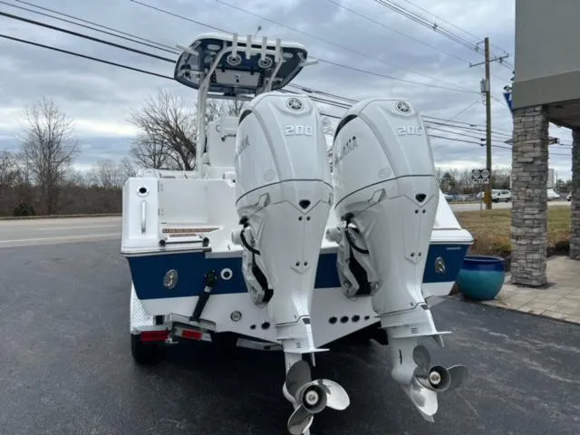 Slide: The Image of 2024 Tidewater 272 CC Adventure boat with dual 200 horsepower engines, parked outdoors. - 9