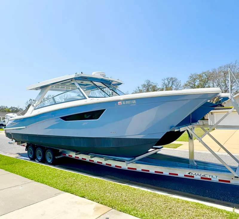 Slide: The Image of 2022 World Cat 400 DC-X boat on trailer, parked outdoors under clear sky. - 0