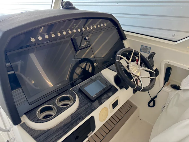 Slide: The Image of 2022 World Cat 400 DC-X boat dashboard with steering wheel and digital displays. - 14