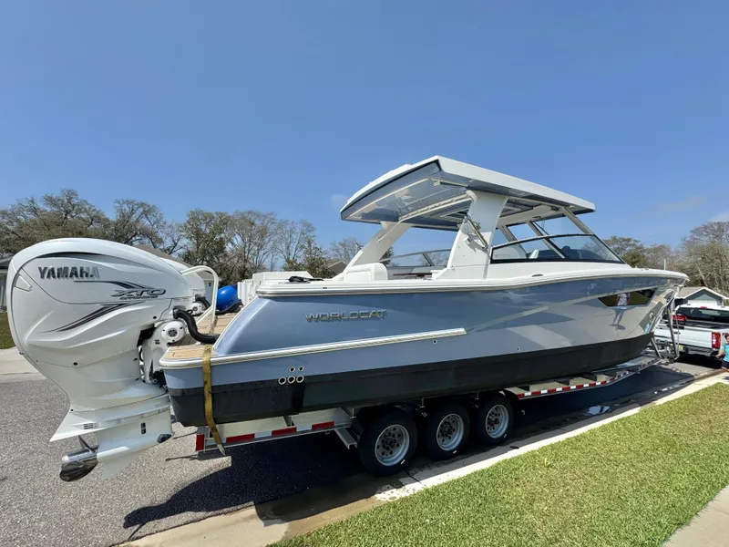 Slide: The Image of 2022 World Cat 400 DC-X boat on trailer with Yamaha engine, parked outdoors. - 2