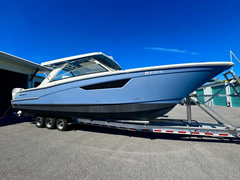 Slide: The Image of 2022 World Cat 400 DC-X boat on trailer, sleek design, blue hull, sunny day. - 3