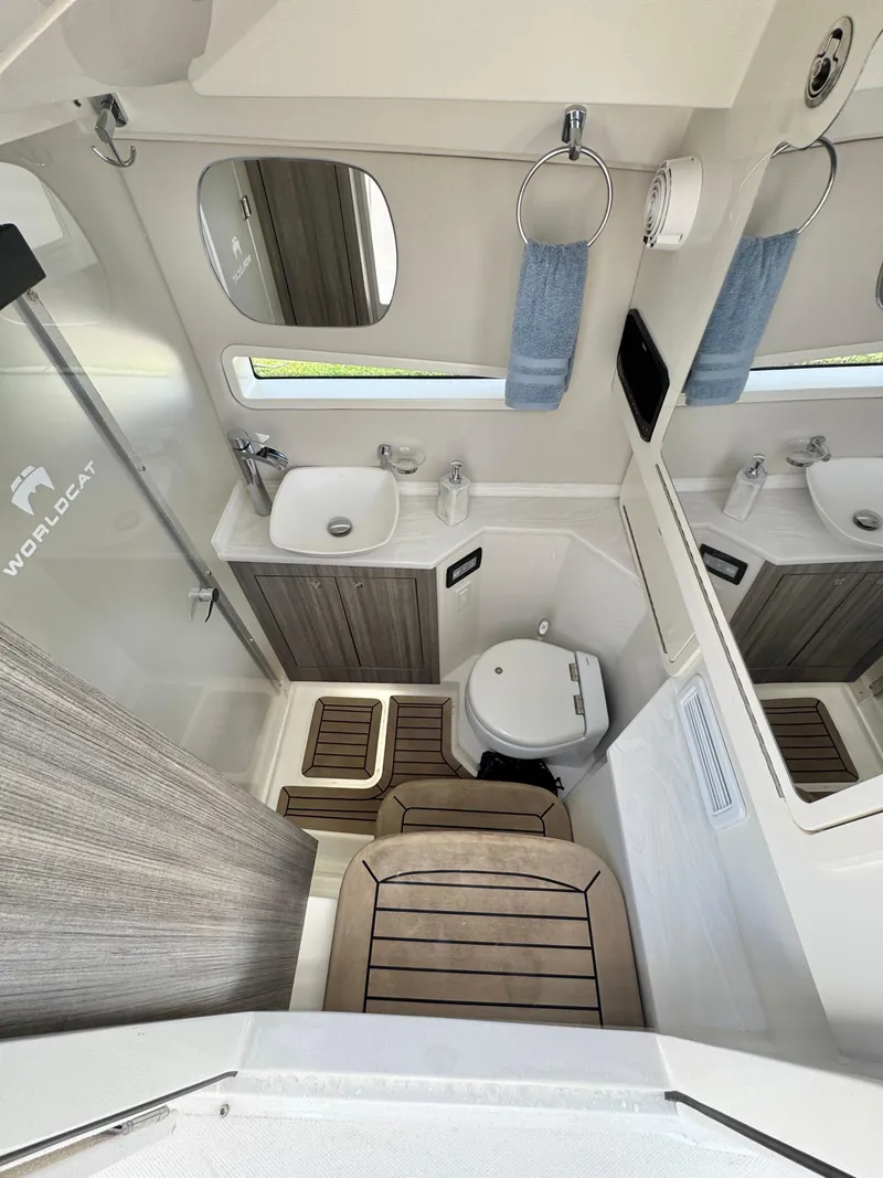 Slide: The Image of Interior of 2022 World Cat 400 DC-X boat bathroom with sink, toilet, and shower. - 30