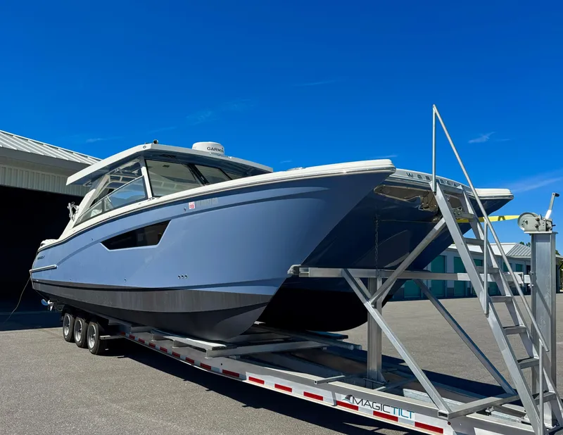 Slide: The Image of 2022 World Cat 400 DC-X boat on trailer under clear blue sky. - 4