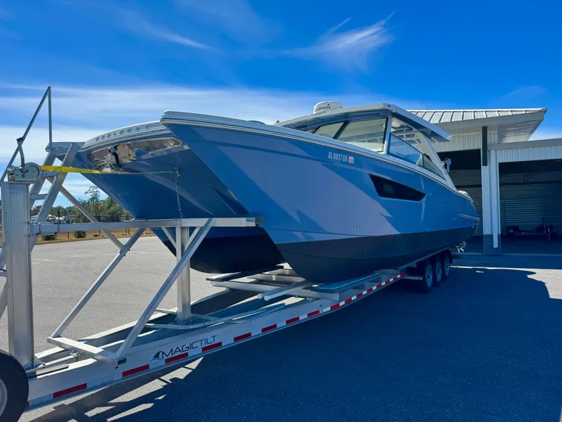 Slide: The Image of 2022 World Cat 400 DC-X boat on trailer, parked outdoors under clear blue sky. - 5