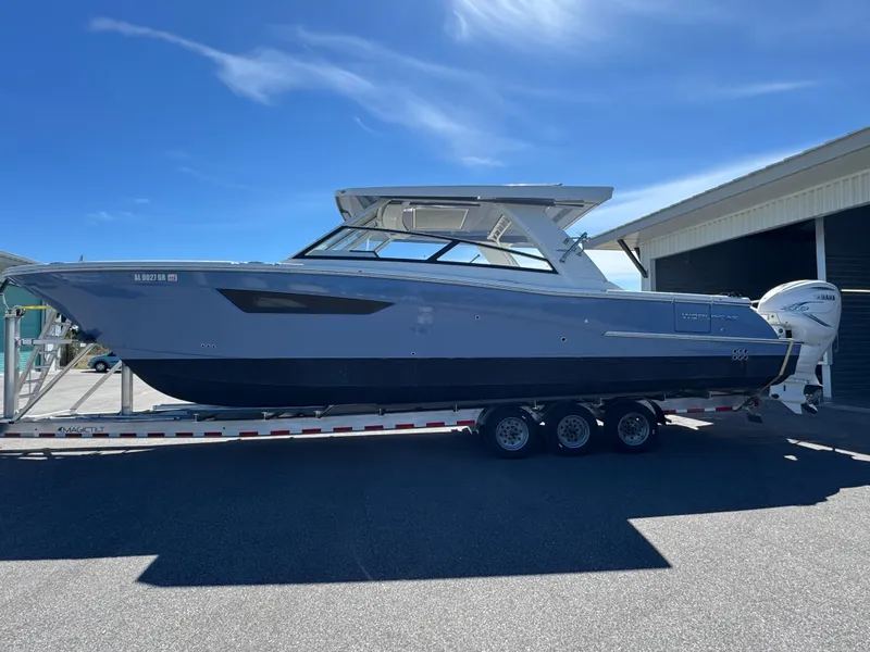 Slide: The Image of 2022 World Cat 400 DC-X boat on trailer under clear blue sky. - 6