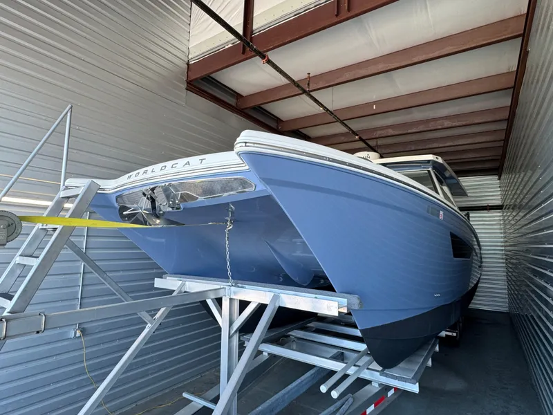 Slide: The Image of 2022 World Cat 400 DC-X boat in storage, blue hull, on a trailer. - 7