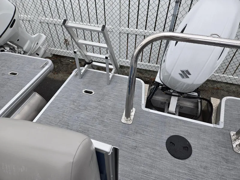 Slide: The Image of 2025 Godfrey Xperience 2286 SBX boat deck with ladder and Suzuki outboard motor. - 18