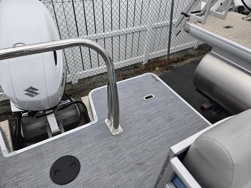 Slide: The Image of 2025 Godfrey Xperience 2286 SBX pontoon boat with Suzuki outboard motor, docked near fence. - 19
