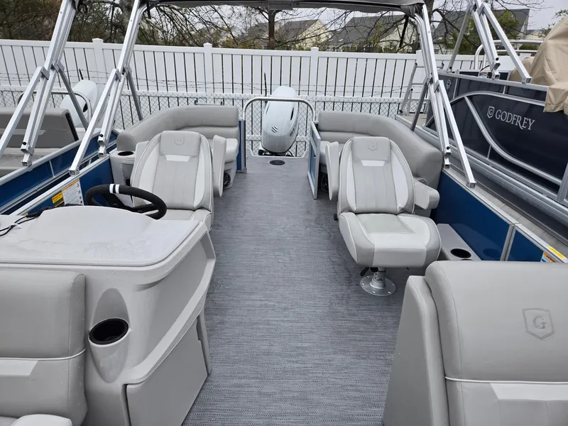 Slide: The Image of 2025 Godfrey Xperience 2286 SBX pontoon boat interior with gray seating and steering console. - 4