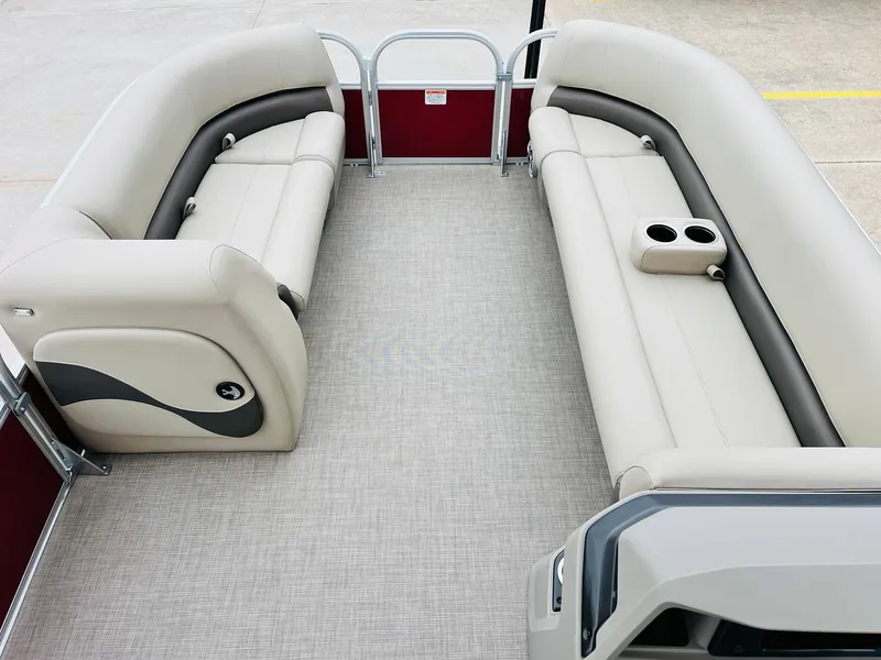 Slide: The Image of 2025 Sun Tracker Party Barge 18 DLX interior with beige seating and cup holders. - 12