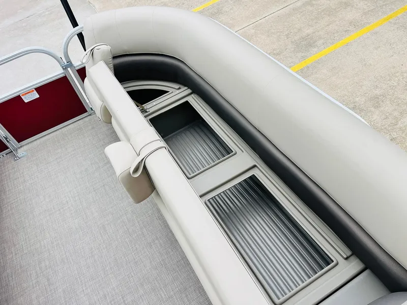 Slide: The Image of 2025 Sun Tracker Party Barge 18 DLX seating with storage compartments, beige upholstery. - 22