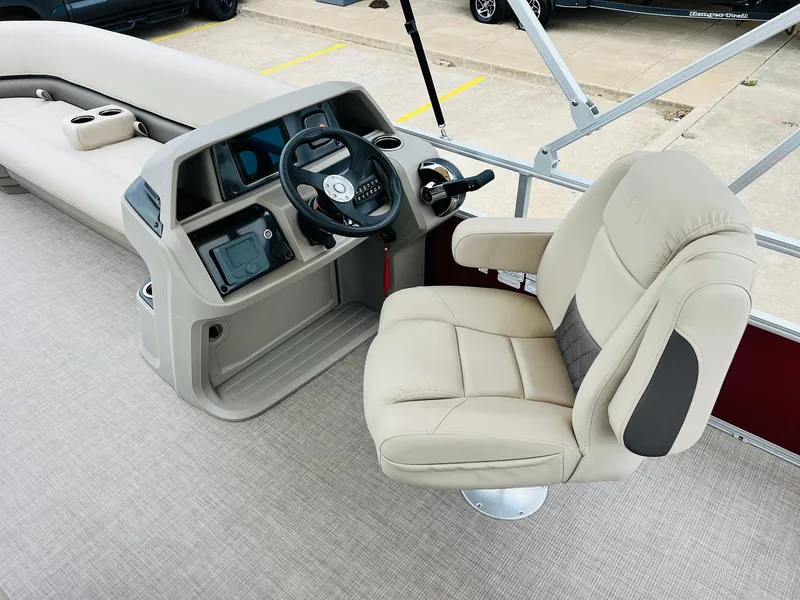 Slide: The Image of 2025 Sun Tracker Party Barge 18 DLX helm with beige captain's chair and steering console. - 27
